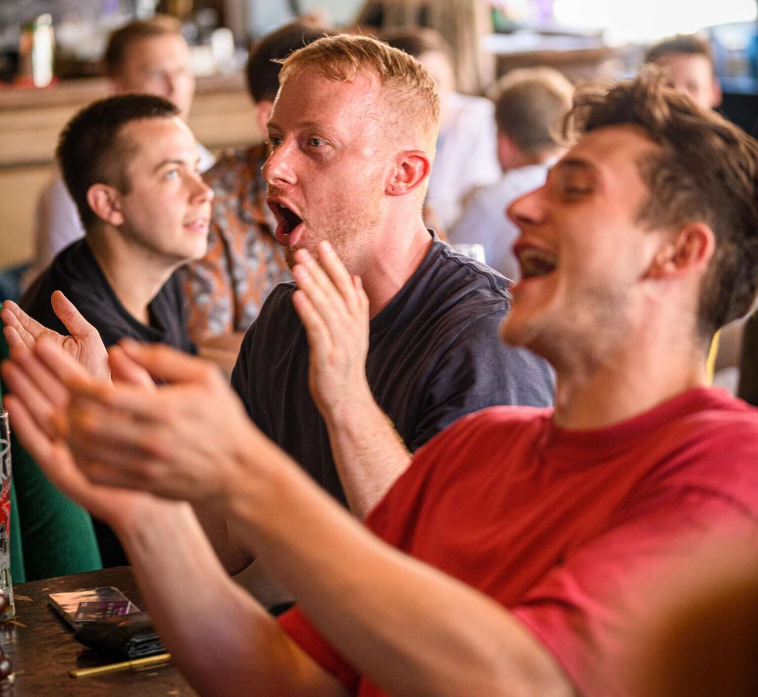 Friends clapping watching the football